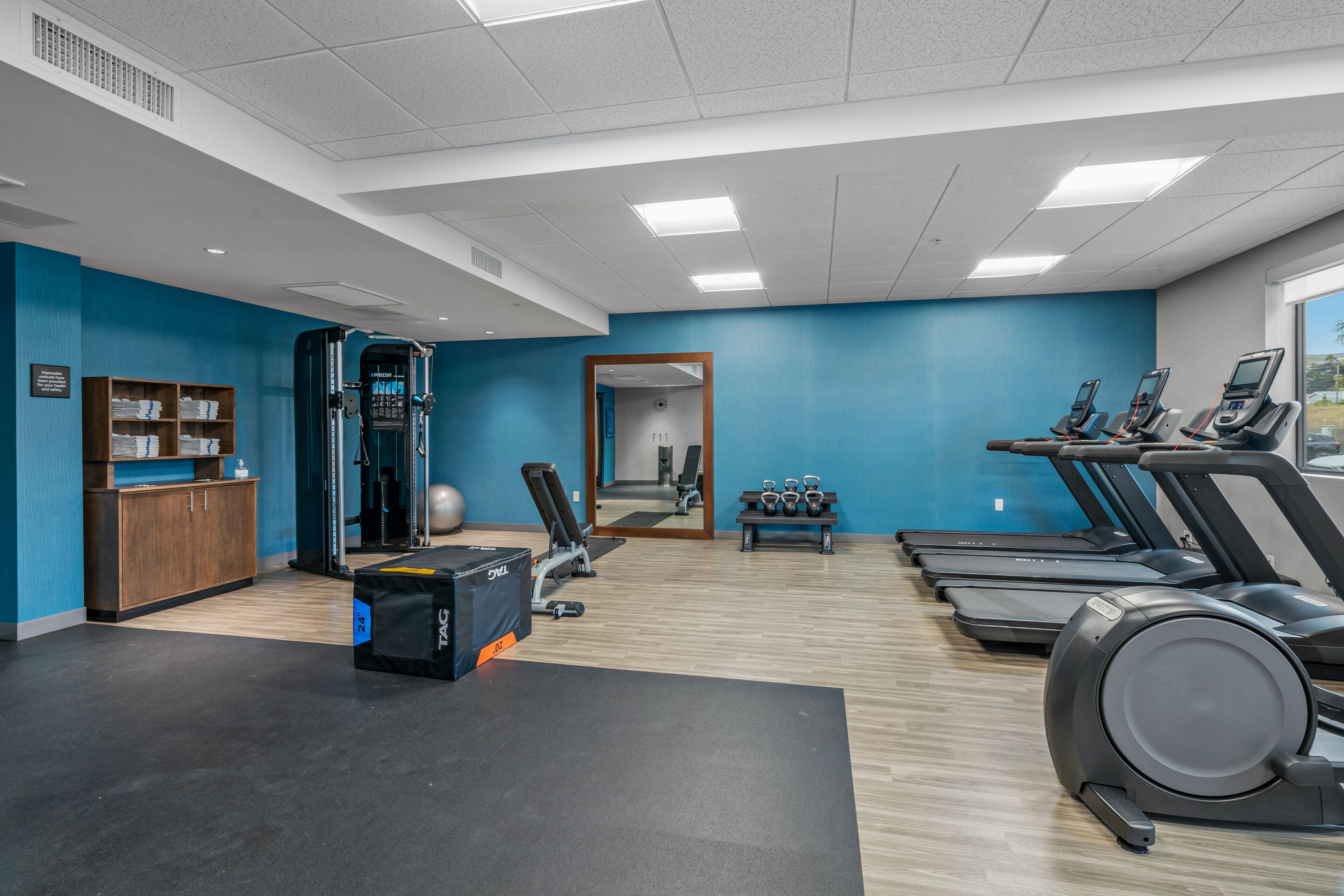 Un gimnasio con cintas de correr, pesas y equipo de ejercicio.