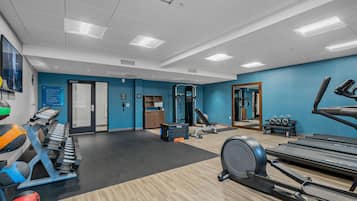 Uma academia com esteiras, elípticos e equipamentos de musculação.