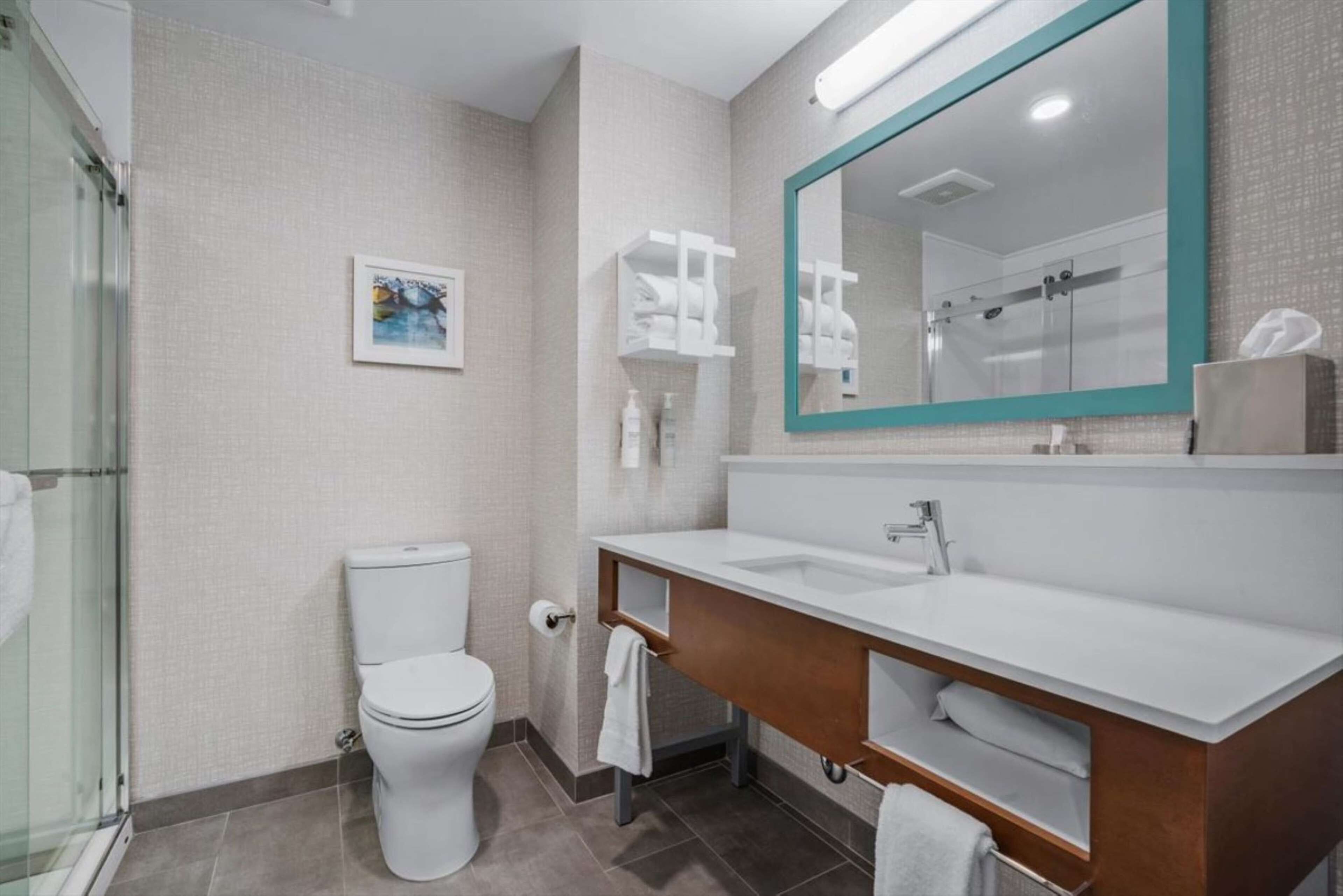 A modern bathroom with a toilet, sink, and shower.