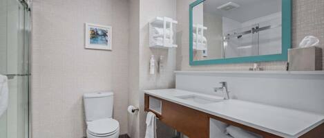 A modern bathroom with a toilet, sink, and shower.