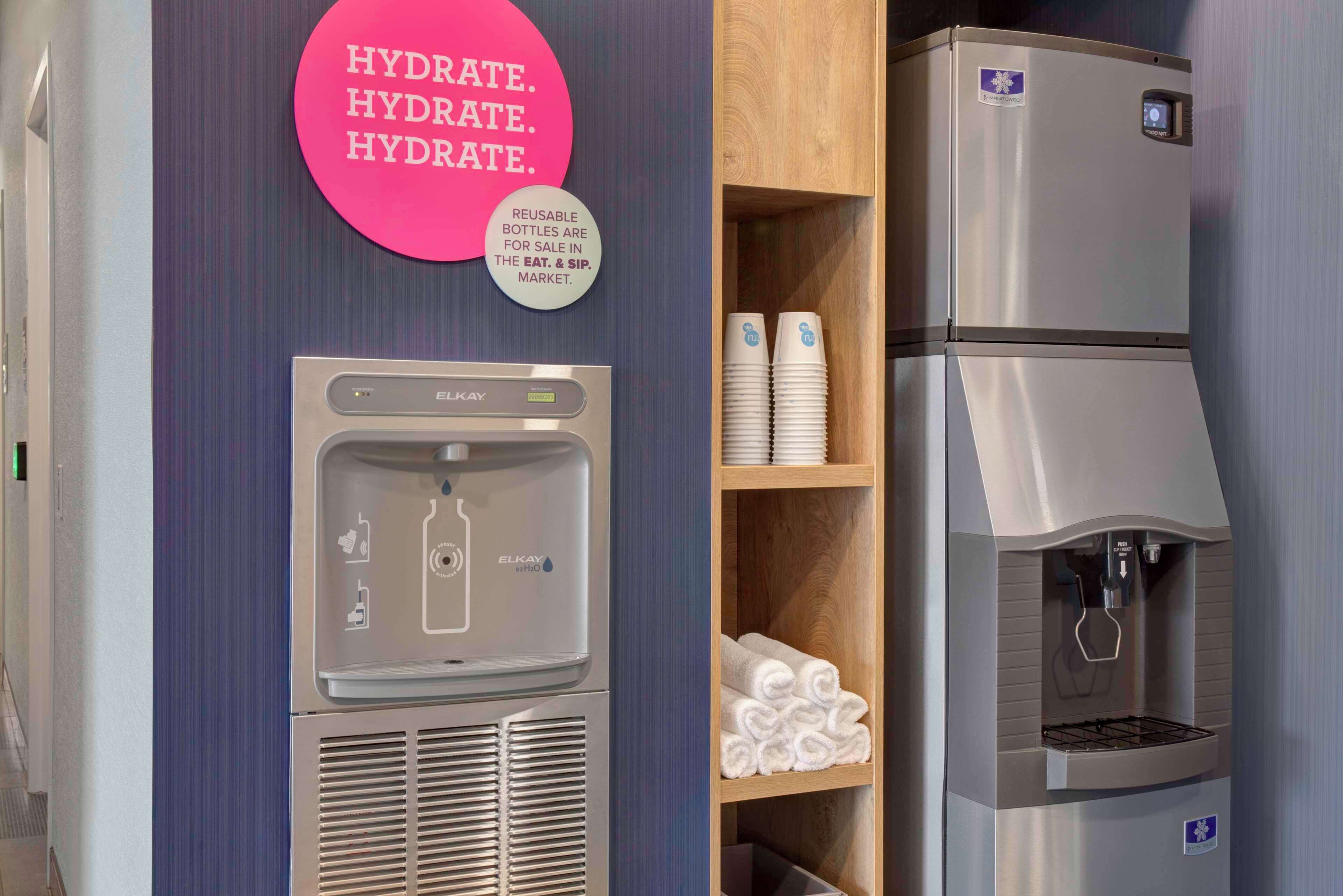 Un dispensador de agua y un refrigerador en una habitación de hotel.