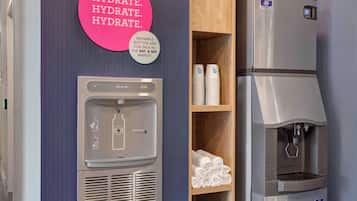 Un dispensador de agua y un refrigerador en una habitación de hotel.