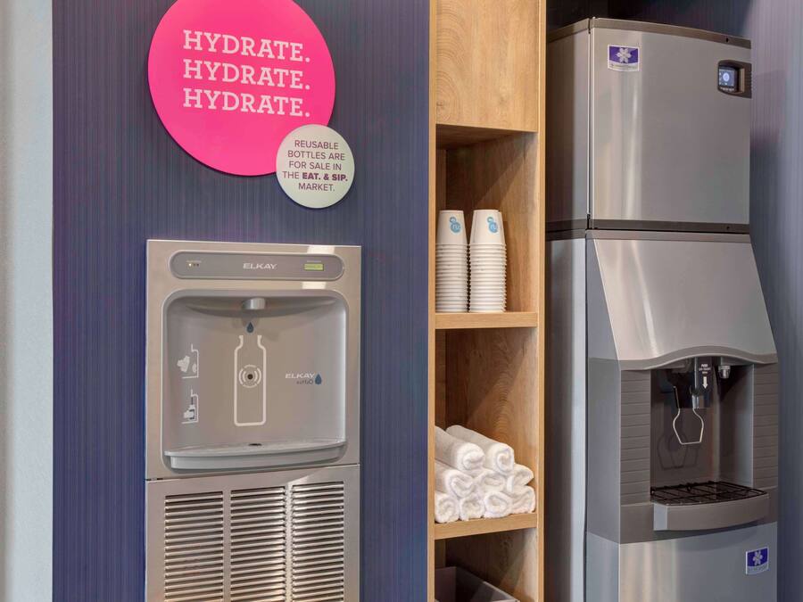 Un dispensador de agua y un refrigerador en una habitación de hotel.