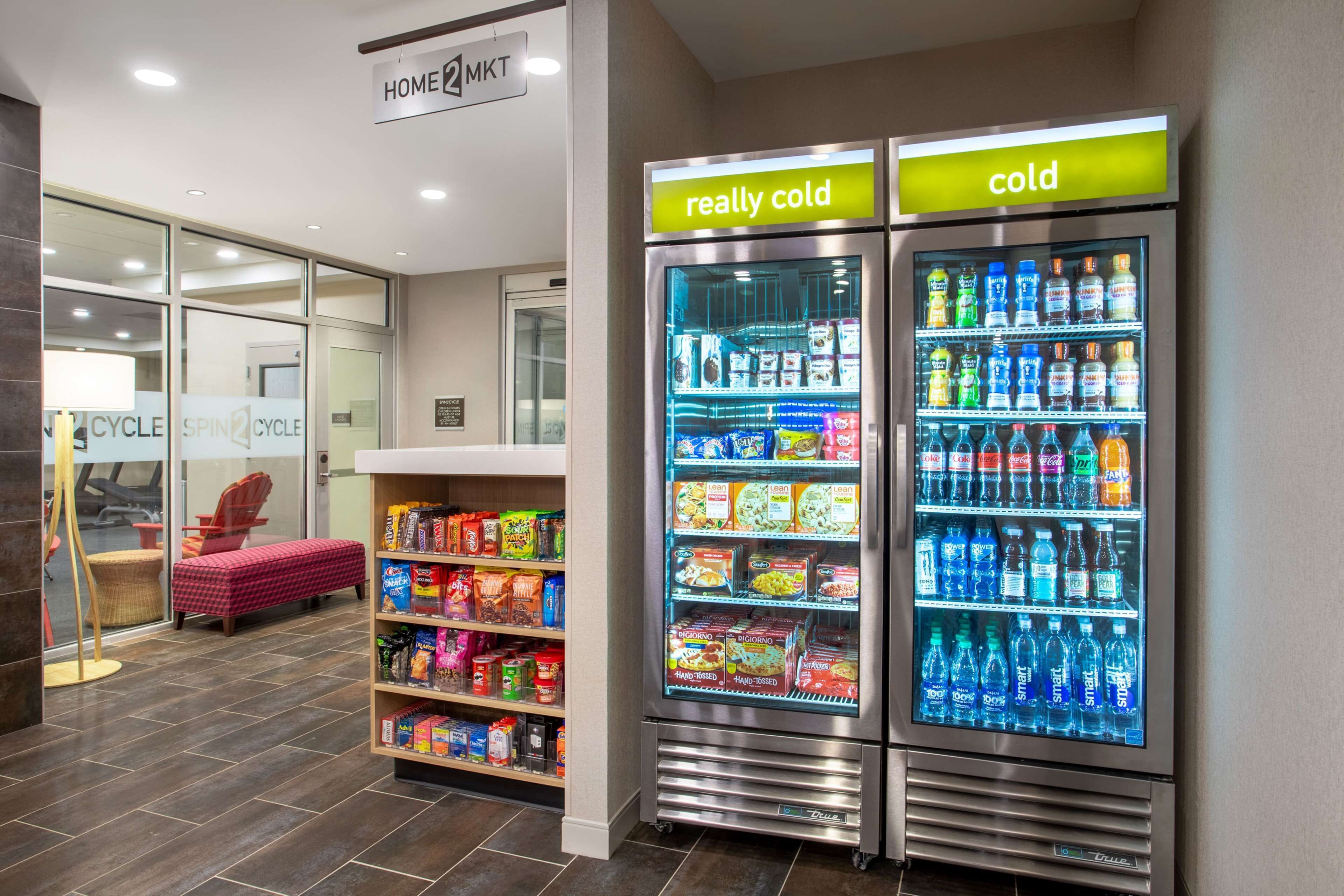 A hotel lobby with a vending machine labeled "really cold" and "cold," stocked with snacks and beverages.