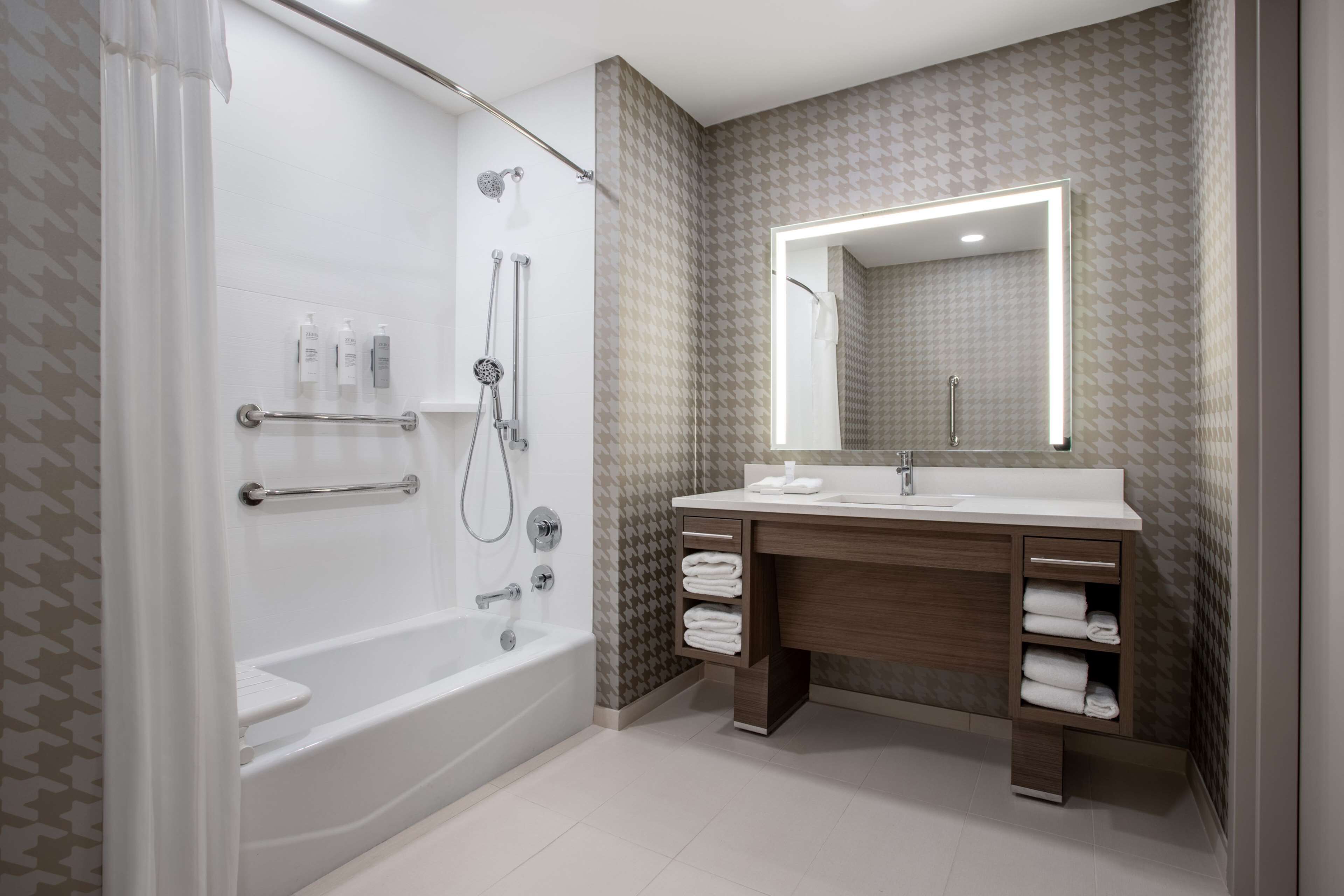 A modern bathroom with a walk-in shower, a vanity with a mirror, and a bathtub.