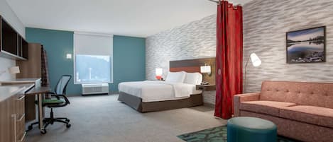 Een hotelkamer met een bed, een bureau, een stoel, een bank en een lamp.