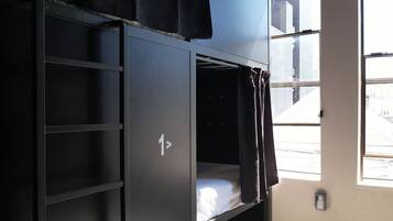 Un lit superposé avec une fenêtre, une porte et un sol à motifs.