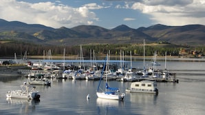 A marina with boats docked, surrounded by mountains and a clear sky.