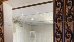 A shower area with white tiles, a showerhead, and a white shelf. - Relaxed house in Well located, Authentic, tranquil and unspoilt fishing village. (Tonosi)