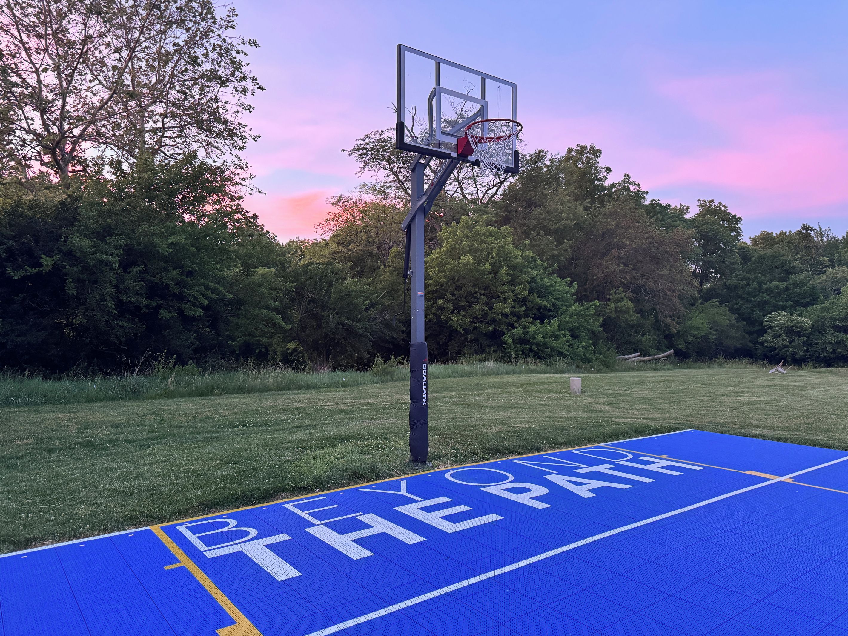 Een basketbalveld met een blauw oppervlak waarop 'BEYOND THE PATH' staat geschilderd.