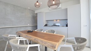 A modern kitchen with a central island, white chairs, and pendant lighting. - Amazing home in Marina di Ragusa (Marina di Ragusa)