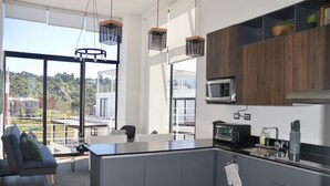 Una cocina moderna con una isla grande, electrodomésticos integrados y vistas al exterior.