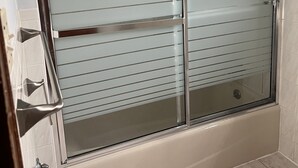 Et moderne badeværelse med et glasvægshus og badekar.