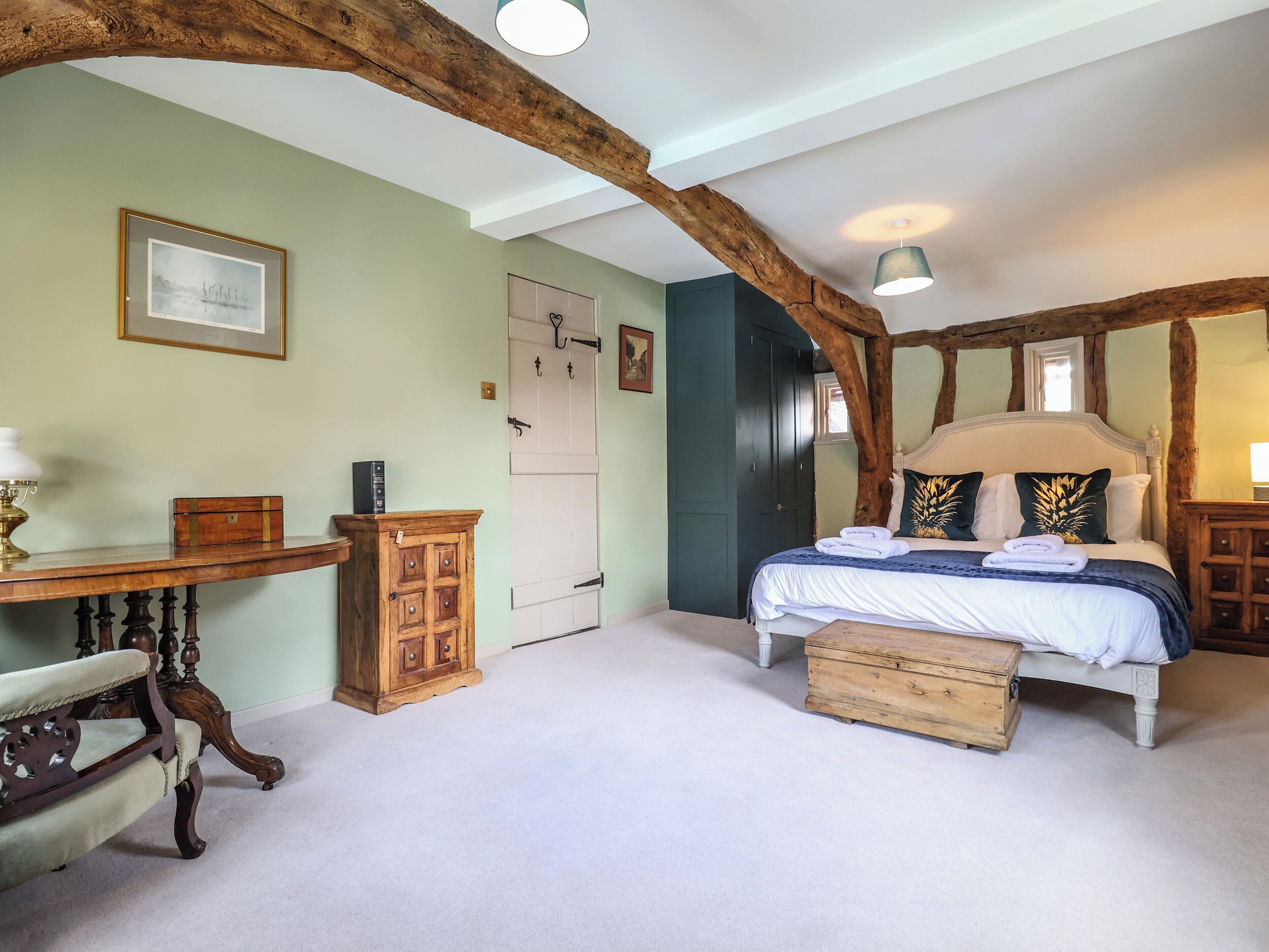A bedroom with a bed, a desk, a chair, and a wardrobe.