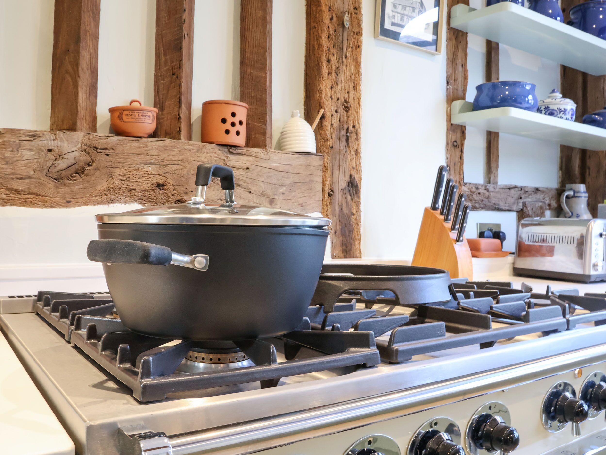 A kitchen with a stove, pots, and a toaster.