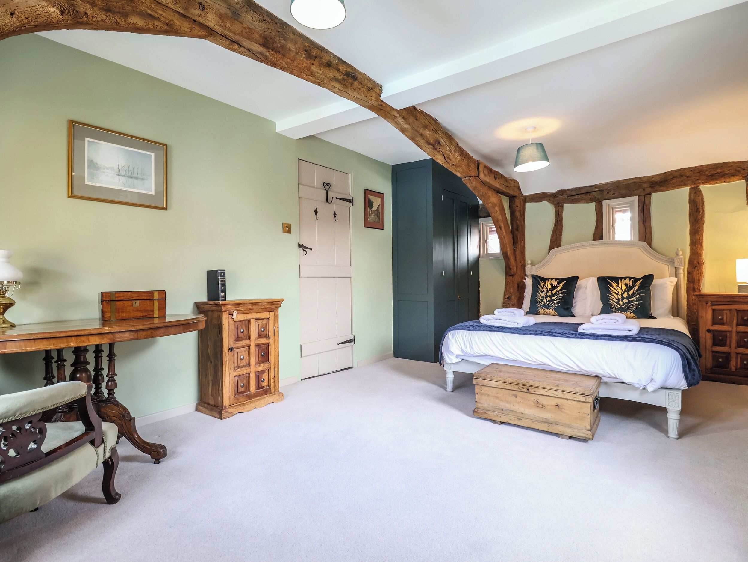 A bedroom with a bed, a desk, a chair, and a wardrobe.