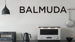 Una cocina con tostadora, hervidor, horno y utensilios de cocina en la pared.