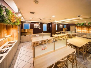 A restaurant with wooden tables and chairs, a counter, and a wall decorated with plants. - Super Hotel Osaka Chikatesu Tanimachi-4chome (Osaka)