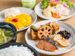 Variedad de platos, incluyendo un tazón de sopa, un plato con tofu, salmón y algas marinas.