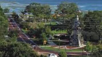 A coastal road with a park area, a statue, and a view of the sea.