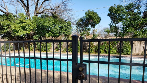 Una piscina con una cerca de metal al frente.