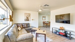 A living room with a sofa, coffee table, and TV. - Kingman Vacation Rental w/ Yard + Fire Pit (Kingman)