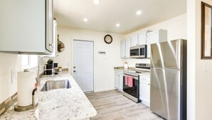 A modern kitchen with stainless steel appliances, a marble countertop, and a wooden floor. - Kingman Vacation Rental w/ Yard + Fire Pit (Kingman)