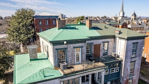 A multi-story building with a green roof, large windows, and a balcony. - Historic Downtown Loft, Private Deck with View and outdoor Firepit (Lynchburg)