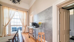 A room with a wooden floor, a desk with a computer, a chair, and a stool. - Historic Downtown Loft, Private Deck with View and outdoor Firepit (Lynchburg)