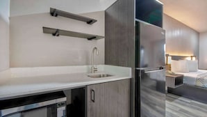 Una cocina moderna con un lavamanos de acero inoxidable, un microondas y un refrigerador.