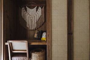 Relax in a cozy space with a wooden chair, woven basket, and macramé wall hanging.