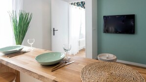 Uma cozinha moderna com bancada de madeira, duas tigelas verdes, uma taça de vinho e um jogo americano trançado.