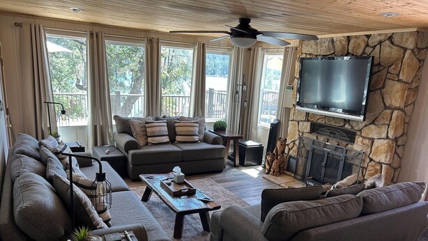 A spacious living room with a stone fireplace, a large flat-screen TV, and a cozy seating area.