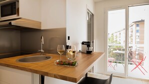 Eine moderne Küche mit Holzarbeitsplatte, Spüle, Mikrowelle und einem Essbereich mit Tisch und Stühlen.