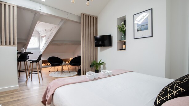 Een moderne slaapkamer met een groot bed, een bureau en een televisie.