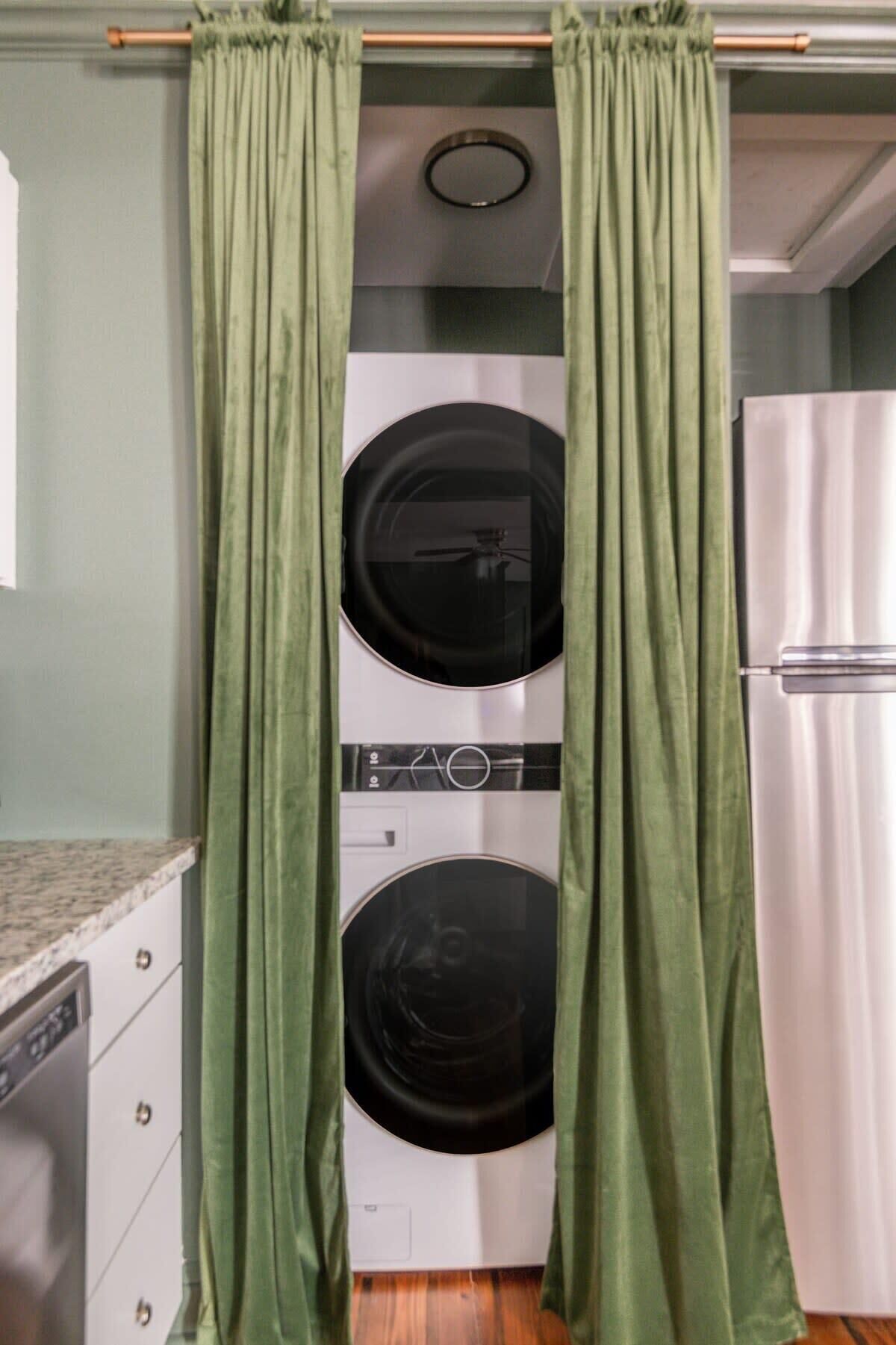 A laundry room with a washing machine, dryer, and a refrigerator.