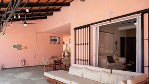 Un salon confortable avec un canapé, une table à manger et des chaises, ainsi qu’un ventilateur de plafond.