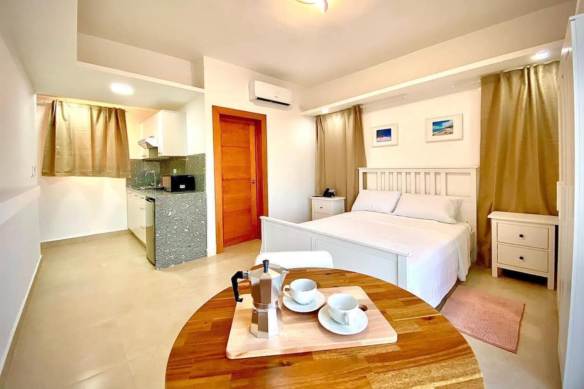 Ein Hotelzimmer mit Bett, Nachttisch und einem Essbereich mit Tisch für zwei Personen.