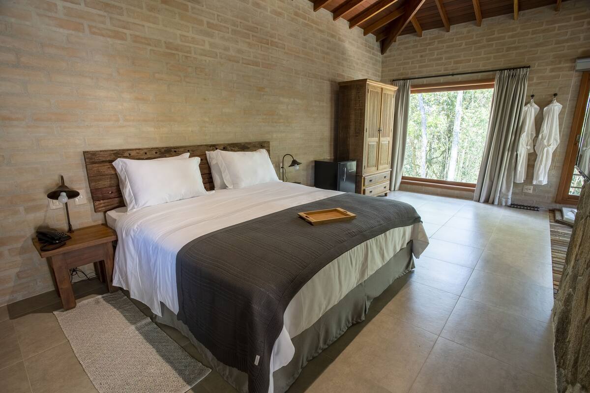 Un dormitorio con una cama grande, cabecera de madera y un armario.