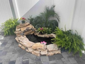 Stroll through the serene garden, surrounded by lush foliage and a tranquil water feature.