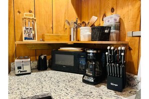 Microwave, toaster, coffee pot, flatware, knife set, and cooking utinsels.