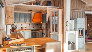 Eine moderne Küche mit Holzausstattung, einer zentralen Kochinsel und einem eingebauten Kamin.