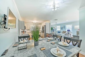 Enjoy meals in this stylish dining area with a marble table and adjacent kitchen.