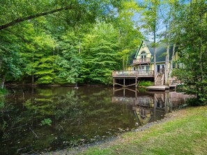 Un chalet au bord du lac, doté d’une terrasse et d’un quai s’avançant dans l’eau.