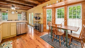 A wooden cabin interior with a kitchen, dining area, and large windows. - 3 BR/3.5 BA w/ Hot Tub & 12 min drive to Ash Cave (New Plymouth)