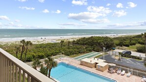 Un área de piscina con vistas a la playa y al océano.
