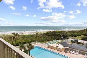 Ein Poolbereich mit Blick auf Strand und Meer.
