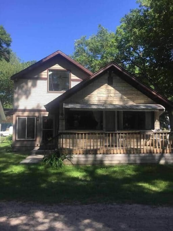 A two-story house with a front porch, a garage, and a visible window.