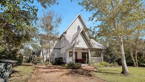 A house with a steep gabled roof, a front porch, and a brick pathway leading to the entrance. - "Will O Mist" - Inlet Beach Home, Bikes, Pool, Dock (Inlet Beach)