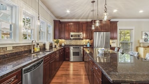 A spacious kitchen with granite countertops, stainless steel appliances, and wooden cabinets. - "Will O Mist" - Inlet Beach Home, Bikes, Pool, Dock (Inlet Beach)